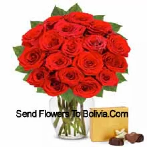 25 красных роз с папоротниками в стеклянной вазе в сопровождении импортного коробка шоколадных конфет