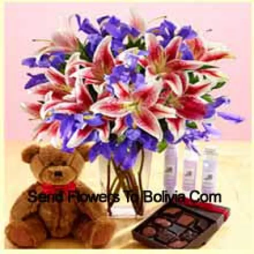 Gigli rosa e fiori assortiti viola disposti splendidamente in un vaso di vetro, un carinissimo orsacchiotto marrone alto 12 pollici e una scatola di cioccolatini importati