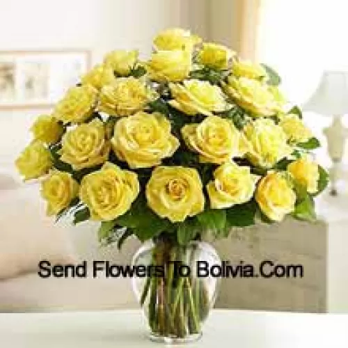 25 желтых роз с папоротниками в стеклянной вазе