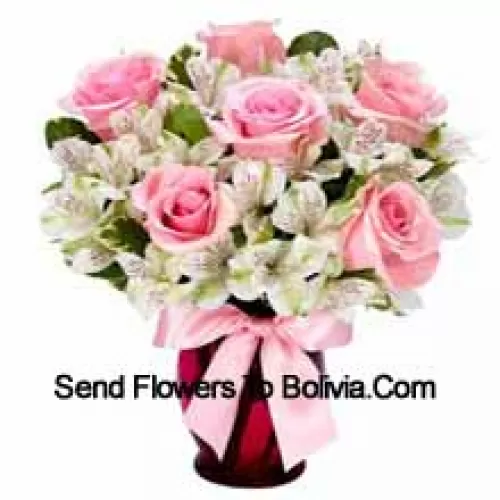 Прекрасные розовые розы и белые альстромерии красиво уложены в стеклянной вазе