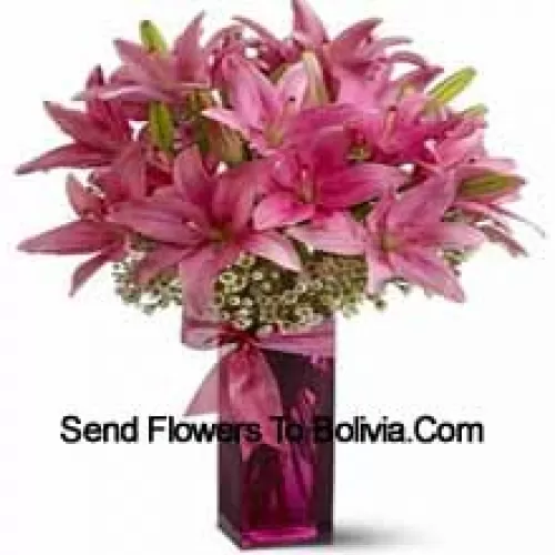 Прекрасные розовые лилии с папоротниками в стеклянной вазе