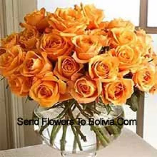 25 оранжевых роз с папоротниками в стеклянной вазе