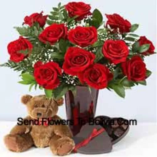 11 punaista ruusua muutamilla saniaislehdillä maljakossa, söpö ruskea 10 tuuman nallekarhu ja sydämenmuotoinen suklaarasia.